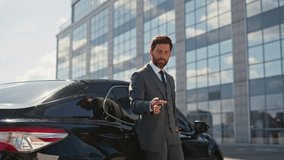 Luxury car owner smiling on business street after buying vehicle zoom in. Happy successful businessman playing with keys leaning on expensive automobile. Rich man satisfied auto purchase close up. - Powered by Shutterstock - Get 15% off with code: PIKWIZARD15