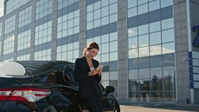Happy business woman texting on cellphone leaning at luxury car outdoors zoom in. Elegant lady smiling looking on smartphone screen at street. Satisfied businesswoman reading phone message close up. - Powered by Shutterstock - Get 15% off with code: PIKWIZARD15