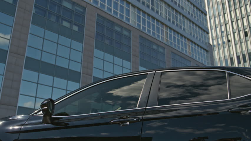 Car owner opening door going outside. Beautiful businesswoman getting out automobile premium class walking to office. Elegant ambitious business lady leaving luxurious vehicle. Wealthy lifestyle.