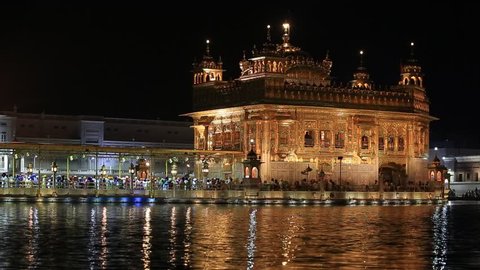 AMRITSAR, INDIA - SEPTEMBER 28, 2014: Unidentified sikhs and indian people visiting the Golden Temple in Amritsar at night. Sikh pilgrims travel from all over India to pray at this holy site.