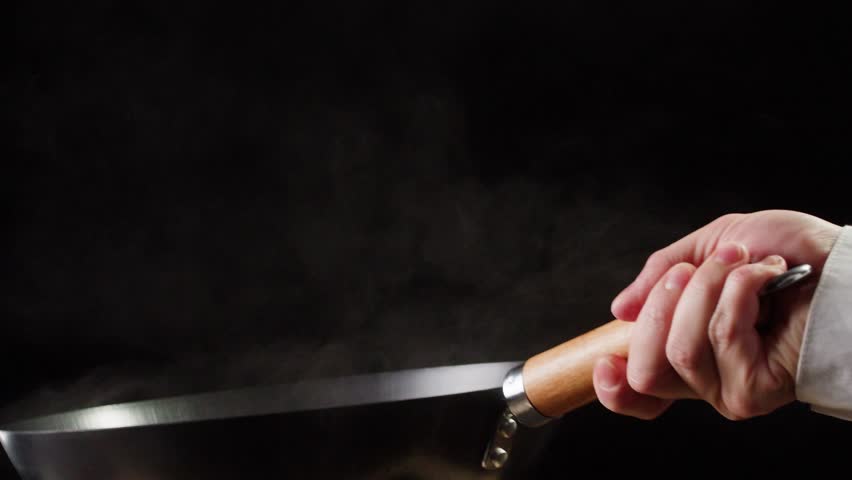 Chef cooking shrimps with oil on wok frying pan close-up. Prawns on fire throwing them on pan. Restaurant Food concept. Sea food.