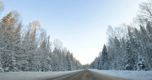 Winter Wonderland Road Trip. Frontal View Along Forest Path
Embark on a winter road trip through a captivating forest path. POV shot. Car journey through snow-covered road. Cinematic color contrast