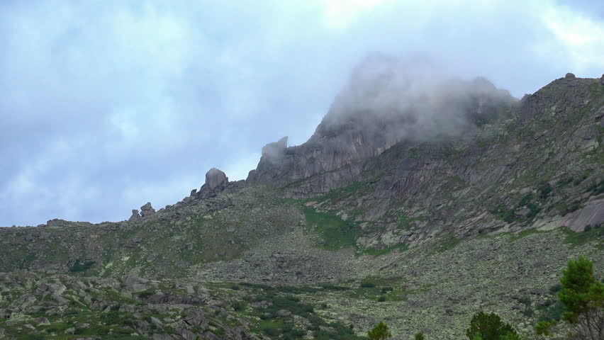 Clouds fly over mountain peak in West Sideria. Timelapse video