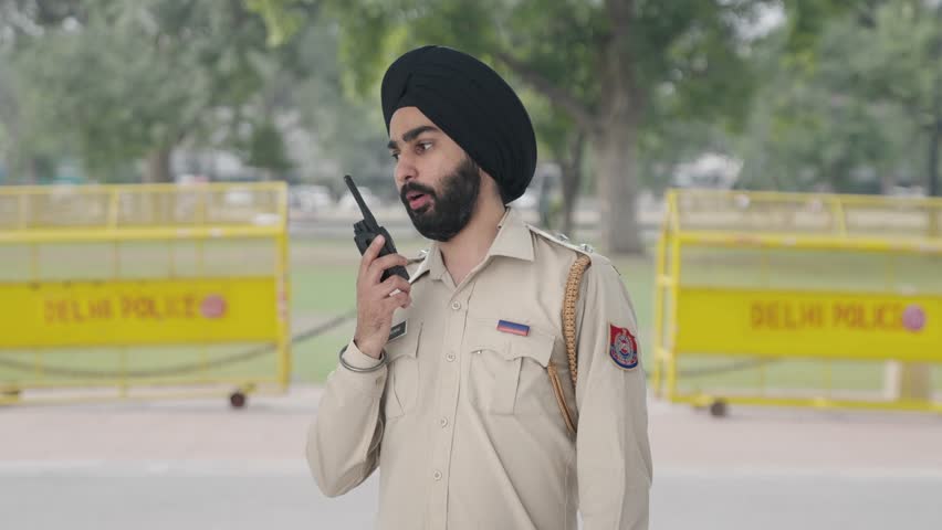Sikh Indian police man talking on radio