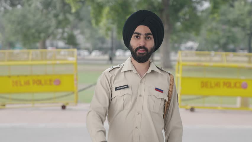 Happy Sikh Indian police man posing with handcuffs