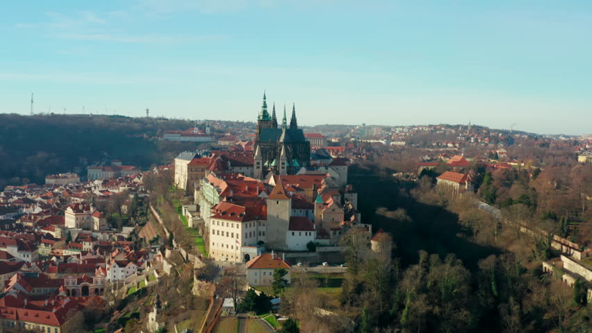 Establishing Aerial view of Prague cityscape, capital of Czech Republic. European Old town view from above with Castle and red roofs skyline. 4K drone zoom in panorama