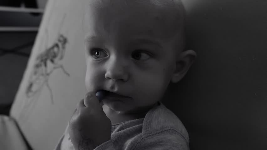A poignant black and white video of a baby in an orphanage, depicting the child's innocence and vulnerability against a monochrome backdrop. baby, living in an orphanage.