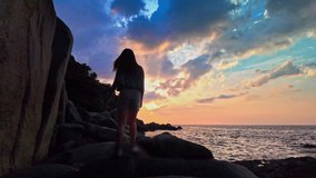
Amazing sunset light through the cloud above the ocean.
a girl walking on the rock.
slow motion wave hit on the rock.

