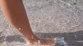 Beautiful female legs walking on sea coast. 4k video footage UHD 3840x2160