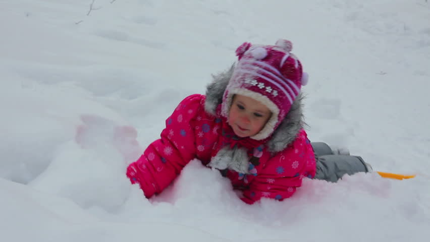 little girl playing in snow at winter
