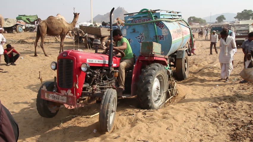 PUSHKAR, INDIA - NOVEMBER 22, 2012: Tractor stuck in sand at fair in Pushkar,