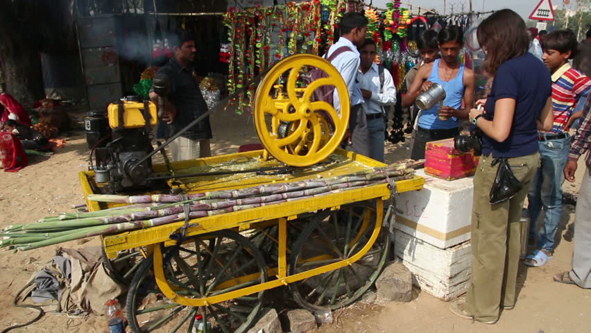 PUSHKAR, INDIA - NOVEMBER 22, 2012: Machine press fresh juice from sugar-cane at