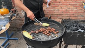 4K video. Chestnut exploded. Celebrating Tbilisoba holiday. Tbilisi City Day, Georgia. Cooking food on the grill. Process of preparing roasted chestnuts and corn. Tongs in male hand. Dish. Man