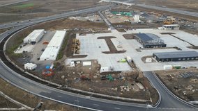 Aerial drone footage of a road construction zone hub filled with machines, equipment and future infrastructure. High angle shot of the process of highway building in Eastern Europe. Infrastructure