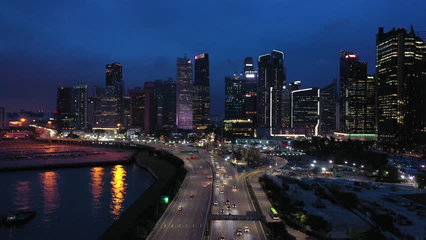 Aerial view, Traffic on the highway road with construction Of the city skyline at night in Singapore.