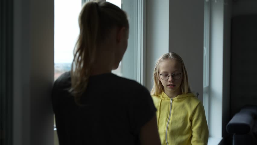 Little sister telling what happened at school to her big sister. Young blond hair teen trying to explain to her angry mother situation at school. Royalty-Free Stock Footage #3409441011