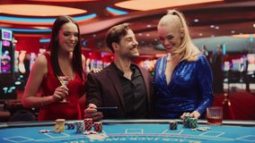 Handsome Man in Suit Uses Smartphone for Online Casino Blackjack Betting, Celebrates Victory with Two Elegant Women. Lucky and Happy Young People Cheering in a Luxurious Casino. Glamorous People - Powered by Shutterstock - Get 15% off with code: PIKWIZARD15