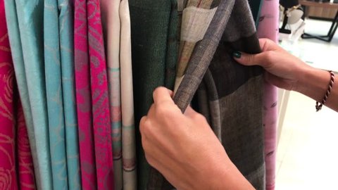 Woman choosing cashmere scarf in the store. Women fashion concept.
