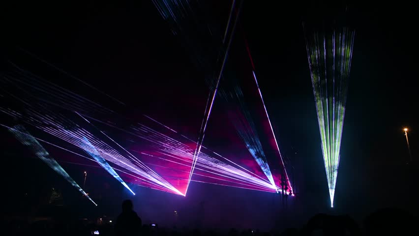 Laser lights and fog on the stage during concert. Multicolored light show at night. Abstract background. Laser beam.