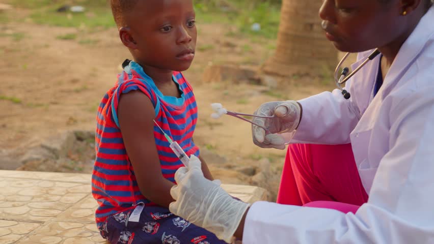 close up of African female doctor in white lab coat giving medical treatment to a black child in remote village of africa, healthcare hospital medical treatment concept in poor undeveloped country  Royalty-Free Stock Footage #3409646403