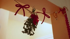 Mistletoe hangs in doorway, with red bows and twine. Holiday decor. - Powered by Shutterstock - Get 15% off with code: PIKWIZARD15