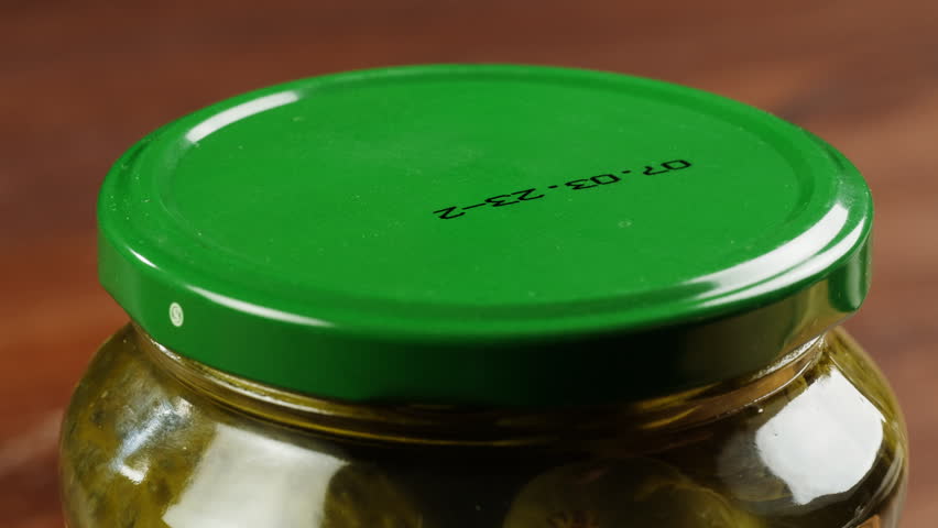  Woman opening Salted pickles in jar can, Cucumbers preservations, conservation. Salted, Hungarian pickled cucumbers in a jar on an old wooden table in the garden with herbs, dill, garlic