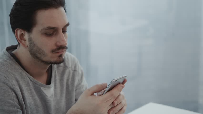 Portrait of young businessman talk on cellphone while stand by his office window in modern interior of skyscraper building, male entrepreneur having mobile phone conversation after important briefing Royalty-Free Stock Footage #34096849