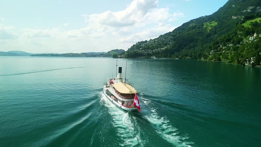 Aerial drone view of steamboat ship in Lake Lucerne. Swiss Flag. Beautiful Swiss Alps nature in summer Switzerland, 4k. Turquoise blue lake water.  Royalty-Free Stock Footage #3409708547
