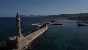 Drone panoramic view over the harbor of Chania on the island of Crete in Greece. Panoramic view from the sky over the city. View of a lighthouse on the sea with cliffs and water waves.