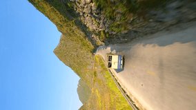Vertical video. Truck driving on scenic mountain road on the Ha Giang Loop, North Vietnam.