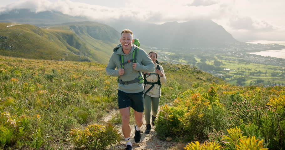 Happy friends walking, hiking on mountain and travel for fitness, adventure and journey in eco friendly wellness. Young people trekking in backpack on a path, green hill or nature for cardio health Royalty-Free Stock Footage #3409843633