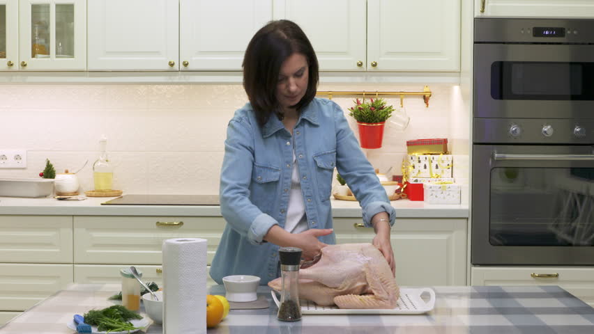 woman cooking roasted stuffed turkey in kitchen, thanksgiving and christmas holiday dinner