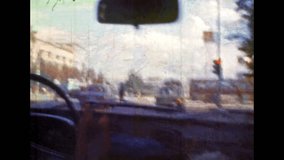 Road city streets view from moving car. Urban traffic view through windshield window of driving transport. Automobile in motion. Urban drive by highway. Vintage color film. Retro archive. Travel 1980s