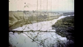 Picturesque river valley view from above. Beautiful natural landscape. Wild nature. Sky over horizon. Scenic river water in green forest. Wilderness panorama. Vintage color film. Retro archive 1980s
