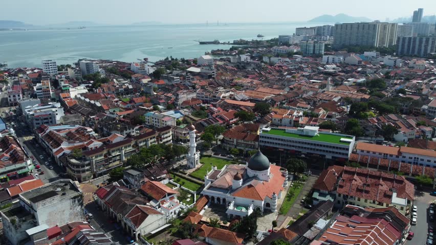 Aerial view of Masjid Kapitan Keling mosque, bottom, built in 19th century by Indian Muslim traders in George Town, Penang, Malaysia. The Malacca strait is seen in the background.