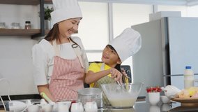 Little toddler asian girl child having fun cooking in the kitchen room at home. Mother is caring and teaching adorable daughter make a bakery and cooking. Family activity. Childen learning concept - Powered by Shutterstock - Get 15% off with code: PIKWIZARD15
