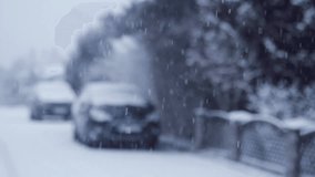 Blizzard - Heavy Snow Storm detail in SLOW MOTION HD VIDEO. Wild falling snowflakes in the wind. Low depth of field and street with car and trees in the background. Quarter speed.