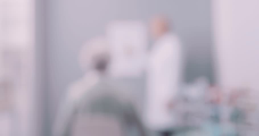 Senior woman having a vision screening: the eye care specialist is pointing at the letters on the eye chart and the patient is reading Royalty-Free Stock Footage #3410006999