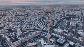 City of Berlin, Germany from above. Aerial winter cityscape view at sunrise or sunset, showing architectural landmarks Oberbaum Bridge, TV Tower and Berlin Cathedral in winter. 