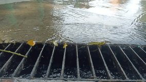 4K video of water overflowing into a drainage. Closeup of water flowing down the drain