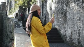 woman with mobile phone making video call with backlight in a tourist place