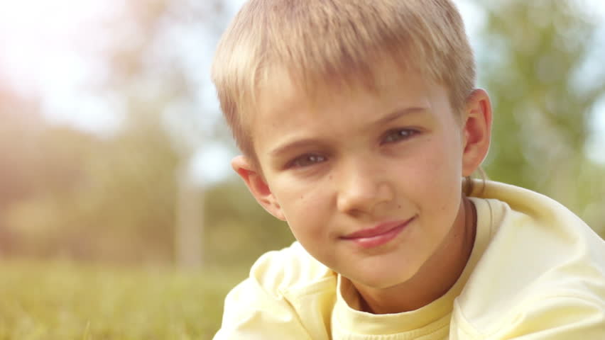 Closeup portrait of a boy looking through binoculars in sunny lights
