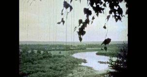 Green river valley view in summer. Beautiful natural landscape. Blue river water flow in scenic forest nature. Wide footage. Vintage color film. Scenery archive. Clean wild environment. Retro 1980s