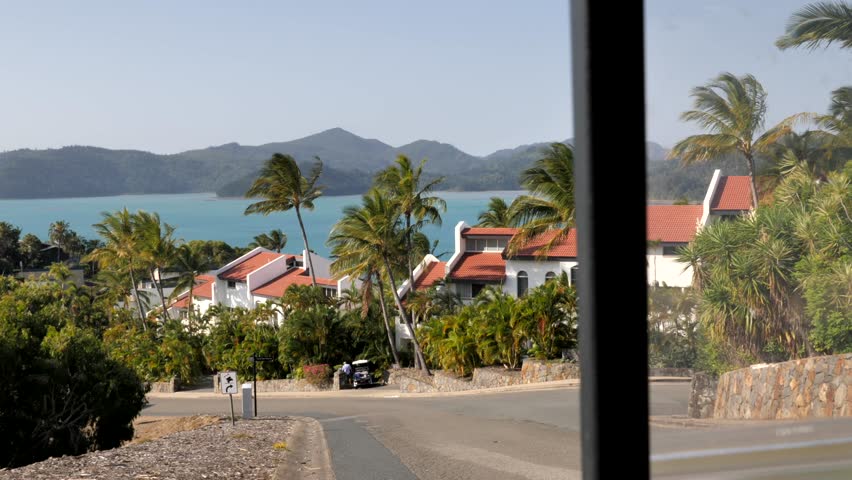 Stunning tropical view of white stucco terrace housing and palm trees on Hamilton Island, Queensland, Australia. Blue sky sunny day with bright blue water.