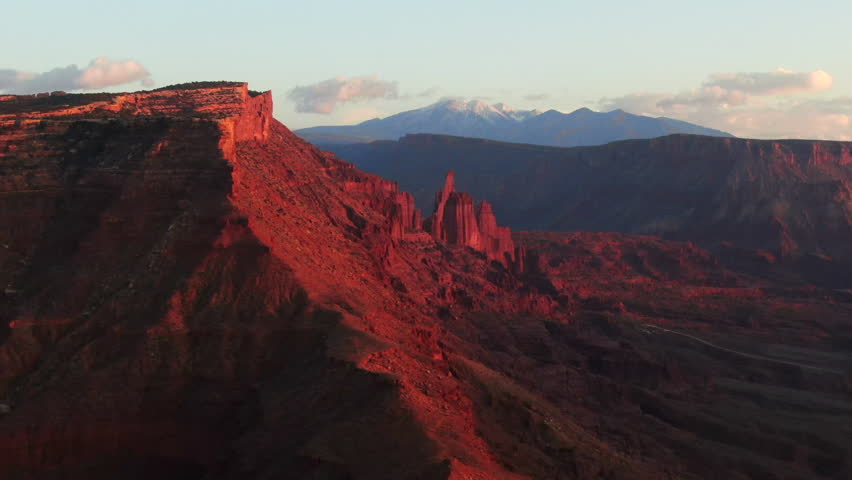 Aerial cinematic drone Moab Utah dramatic orange sunset mountain snow covered peak Big Enchilada landscape Arches National Park Castle Valley Castleton Fishers Tower Green River camping circle right