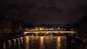 Night in Paris. Beautiful 4K video with a bridge over Seine river in Paris, view to Eiffel Tower, during a winter night. Travel to France.