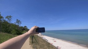 Tourist Capturing Photos and Recording Video of Beach and Polish Sea from an Elevated Viewpoint in 4k slow motion 60fps