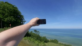 Tourist Capturing Photos and Recording Video of Beach and Polish Sea from an Elevated Viewpoint in 4k slow motion 60fps