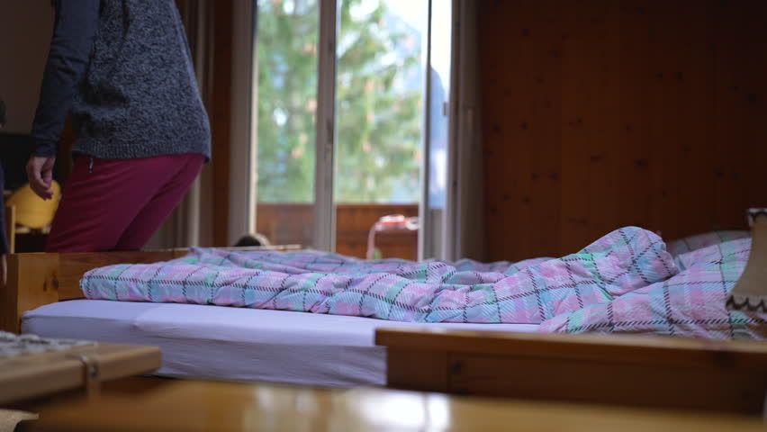 Relaxed Woman Unwinding in Cozy Swiss Mountain Chalet, family vacationing in wooden house, person lays down in bed
