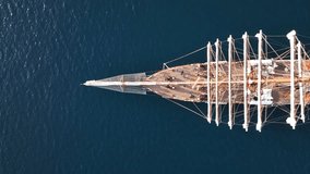 Aerial drone flyover pan video over beautiful 3 mast barque or barc type classic sailing wooden boat one of the largest in the world, anchored in Mediterranean deep blue sea